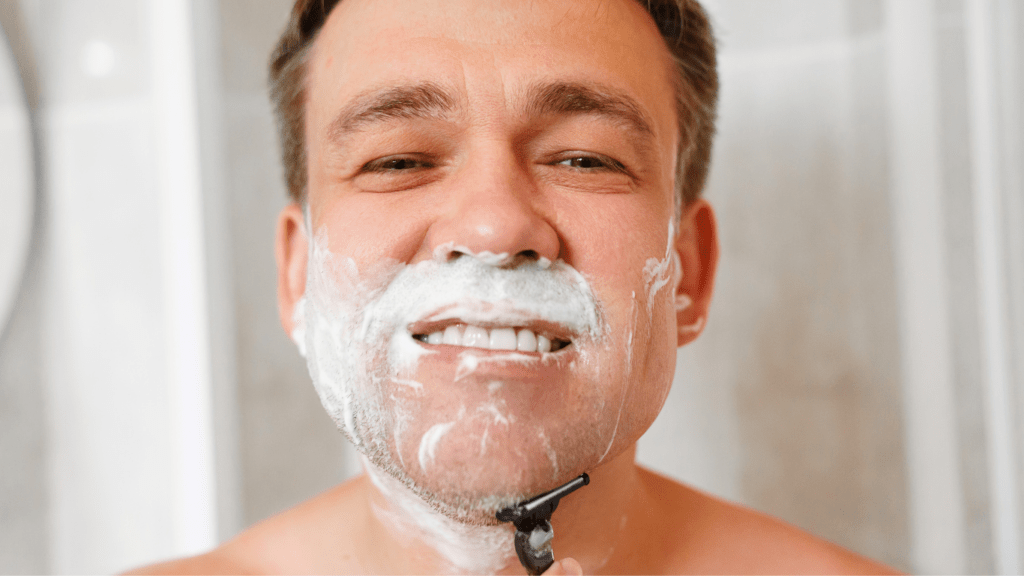 Man shaving the beard with shaving cream